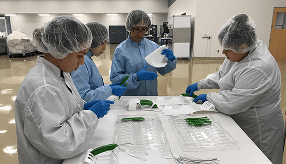 people assembling elevo kits in clean room facility